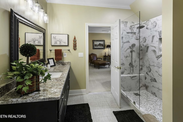 full bathroom with a marble finish shower, vanity, crown molding, and baseboards