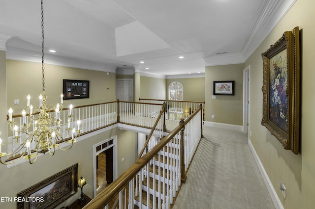 hall featuring an upstairs landing, carpet floors, an inviting chandelier, crown molding, and baseboards