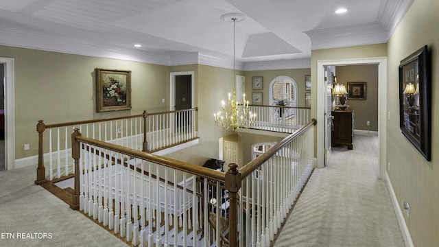 hall with an upstairs landing, a notable chandelier, ornamental molding, carpet flooring, and baseboards