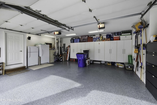 garage with electric panel, a garage door opener, and freestanding refrigerator