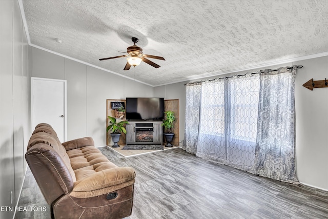 living room featuring lofted ceiling, a textured ceiling, ornamental molding, and a ceiling fan