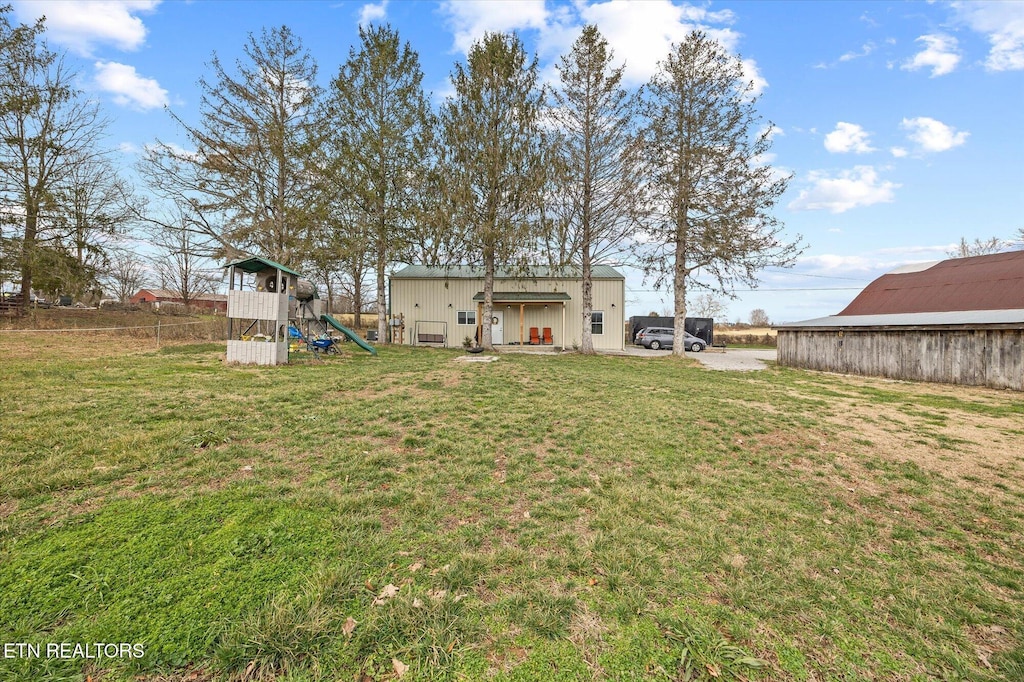 view of yard featuring a playground and an outbuilding