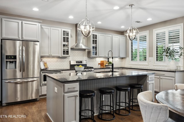 kitchen with visible vents, dark wood-style flooring, stainless steel appliances, a kitchen bar, and a sink