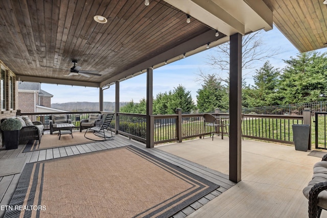 deck with outdoor lounge area, ceiling fan, and fence