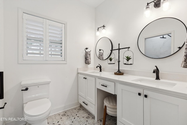 full bath with baseboards, a sink, toilet, and double vanity