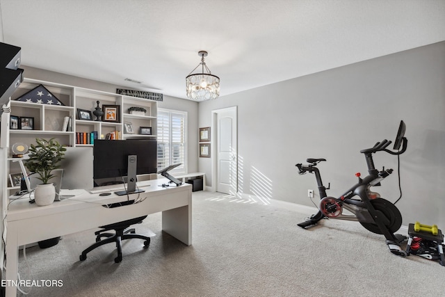 carpeted office space featuring baseboards and a chandelier