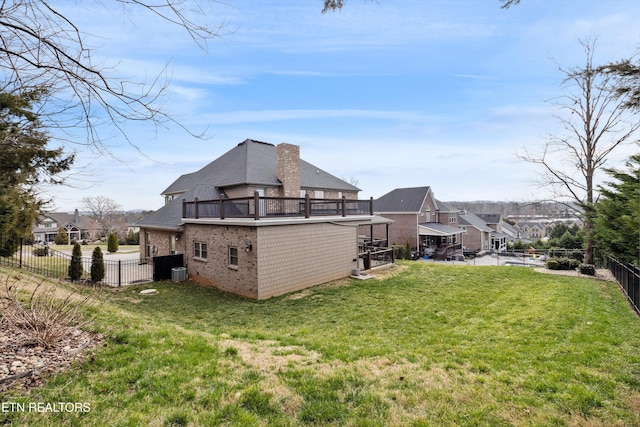 back of property with a fenced backyard, central air condition unit, brick siding, a lawn, and a chimney