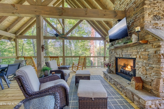 sunroom featuring vaulted ceiling with beams, wooden ceiling, and an outdoor stone fireplace