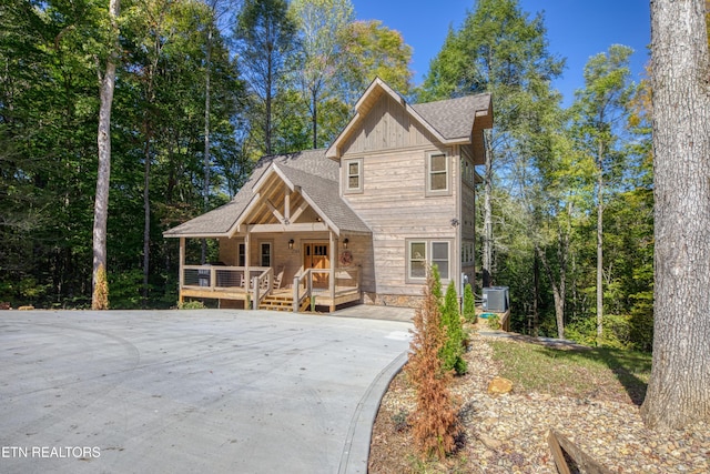 view of front of home with central AC unit, board and batten siding, and a shingled roof