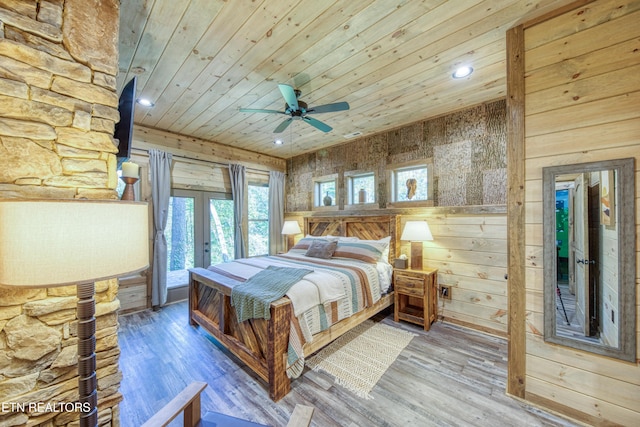 bedroom featuring wooden walls, wood finished floors, wood ceiling, access to exterior, and french doors