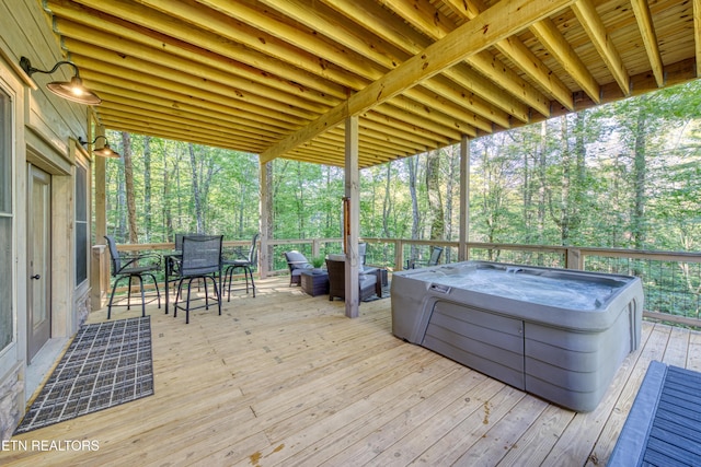 wooden deck featuring outdoor dining area and a hot tub