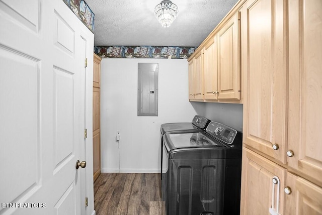 laundry area featuring a textured ceiling, washing machine and dryer, cabinet space, electric panel, and dark wood-style floors