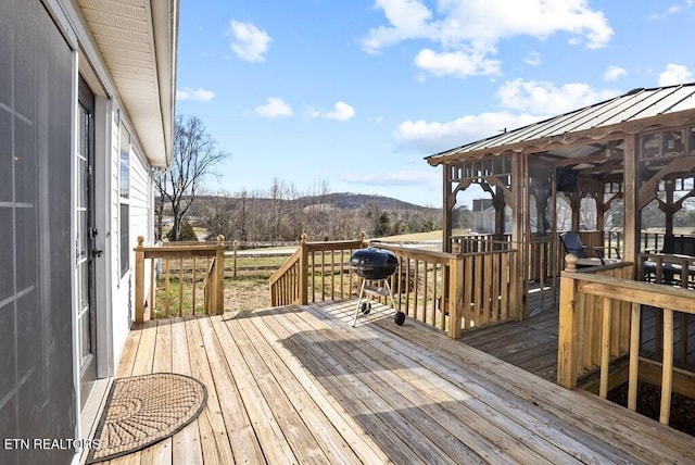 deck with a grill and a mountain view