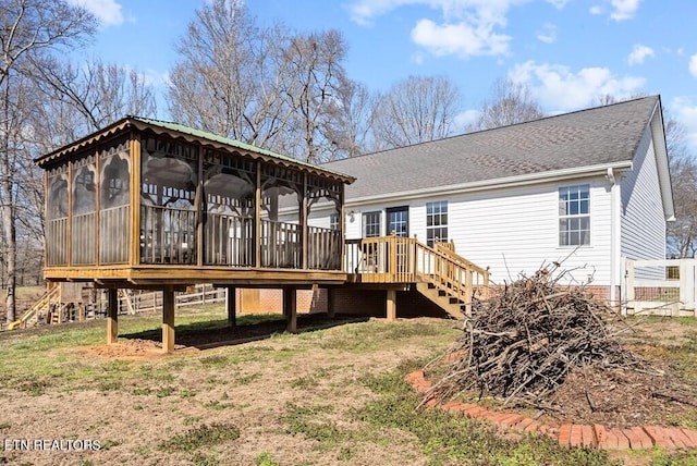 back of house with a sunroom, a shingled roof, and stairway