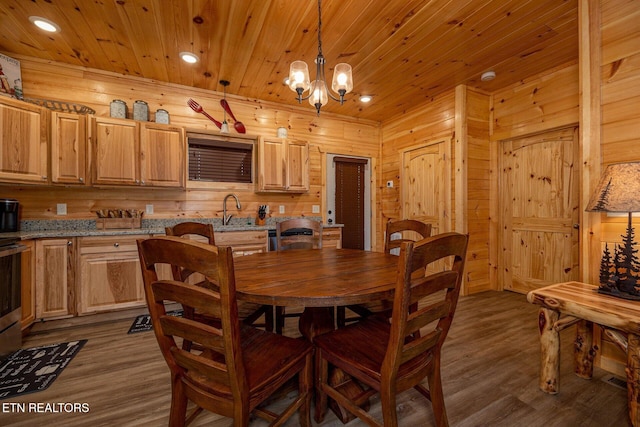 dining room with dark wood-style floors, wooden ceiling, wooden walls, and an inviting chandelier