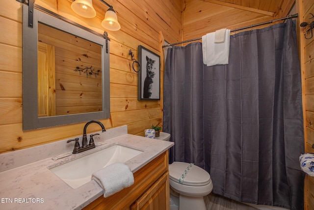 bathroom with toilet, wooden walls, a shower with shower curtain, and vanity