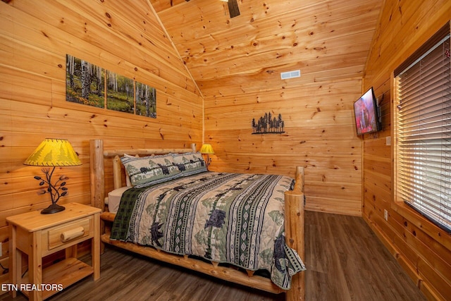 bedroom featuring lofted ceiling, wood walls, and wood finished floors