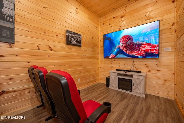 cinema room featuring wood finished floors and wooden walls