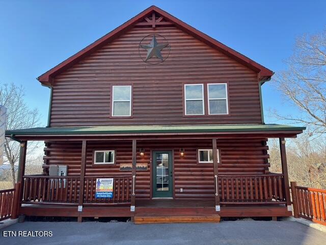 back of house featuring log siding and a porch