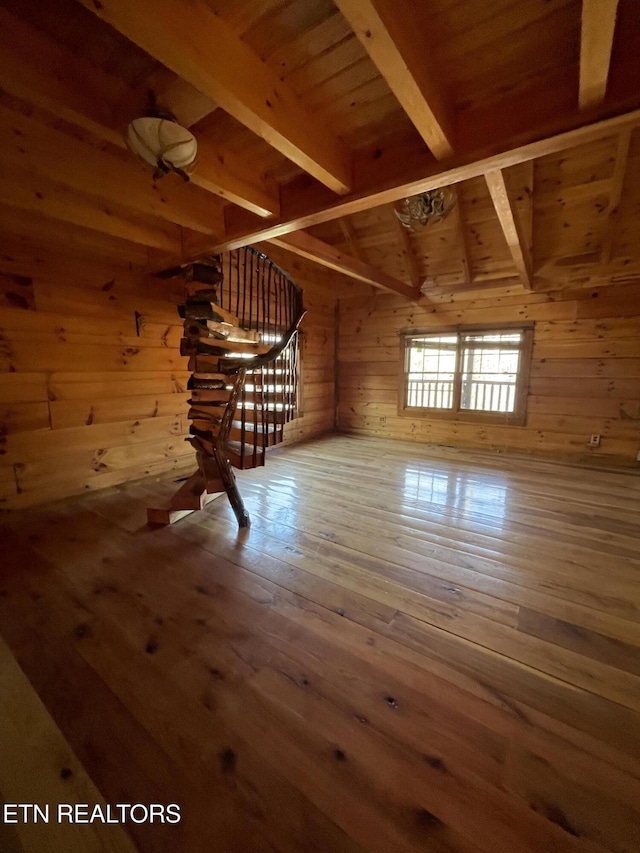 interior space with wood walls, wood ceiling, beam ceiling, and hardwood / wood-style floors