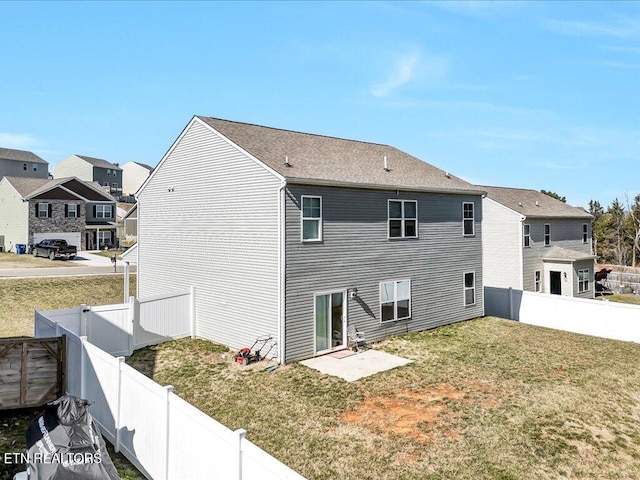 rear view of property with a lawn and a fenced backyard