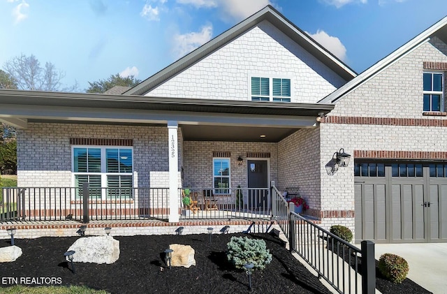 view of front of property with a garage, a porch, and brick siding