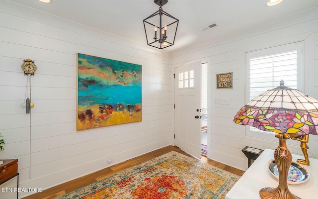 foyer entrance featuring baseboards, wood finished floors, visible vents, and recessed lighting