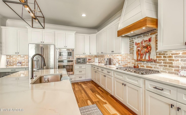 kitchen featuring appliances with stainless steel finishes, white cabinets, and a sink