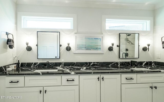 bathroom with double vanity and a stall shower