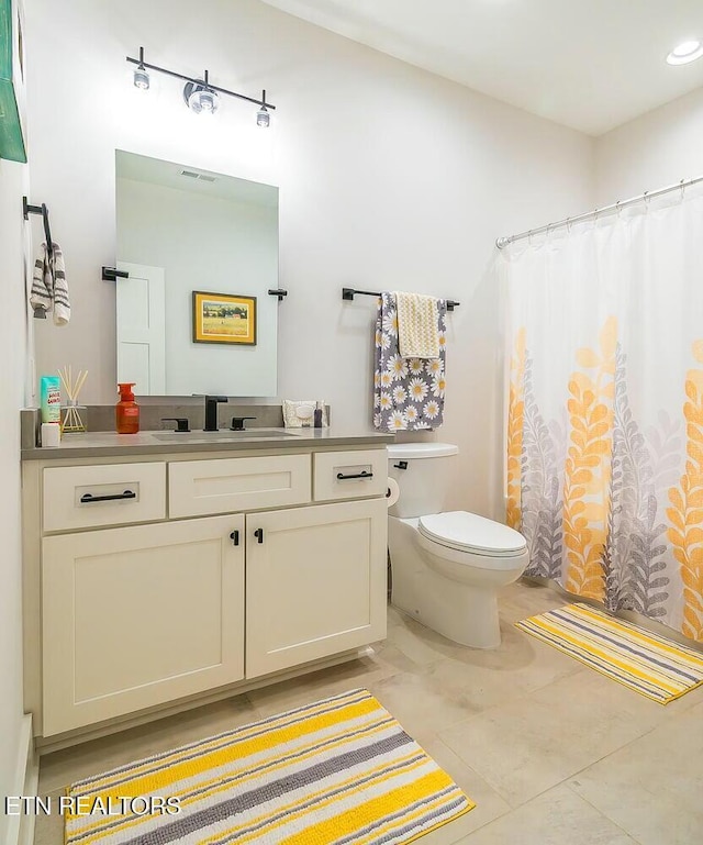 bathroom with toilet, a shower with curtain, visible vents, and vanity