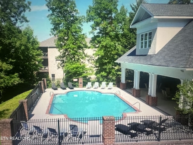 pool featuring fence and a patio