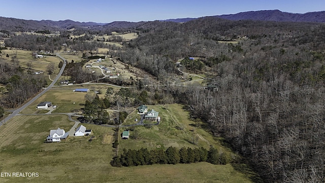 drone / aerial view featuring a wooded view and a mountain view