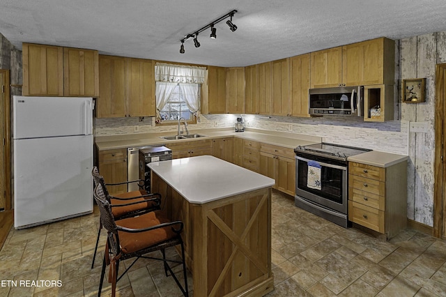 kitchen featuring a textured ceiling, stainless steel appliances, a sink, and light countertops