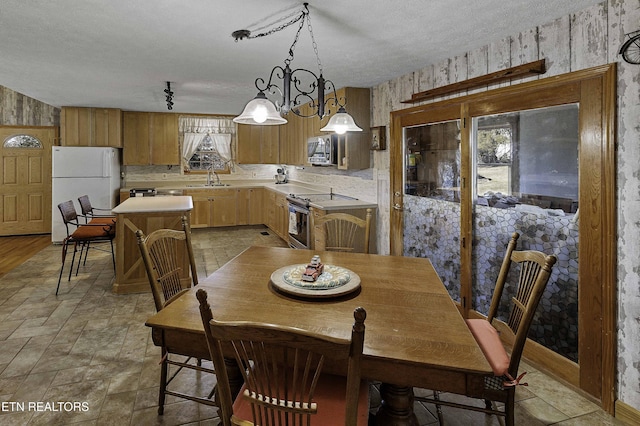 dining area with stone finish floor, a textured ceiling, and wallpapered walls