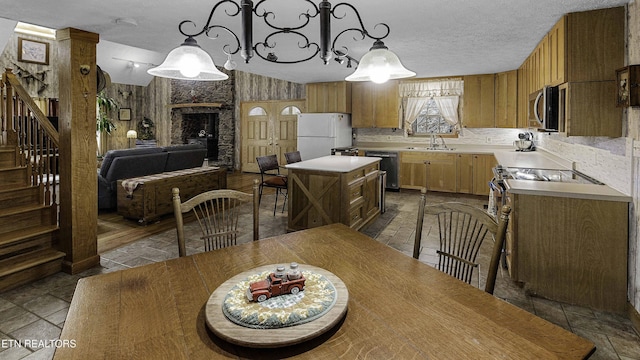 dining room with a textured ceiling, stairway, and a fireplace