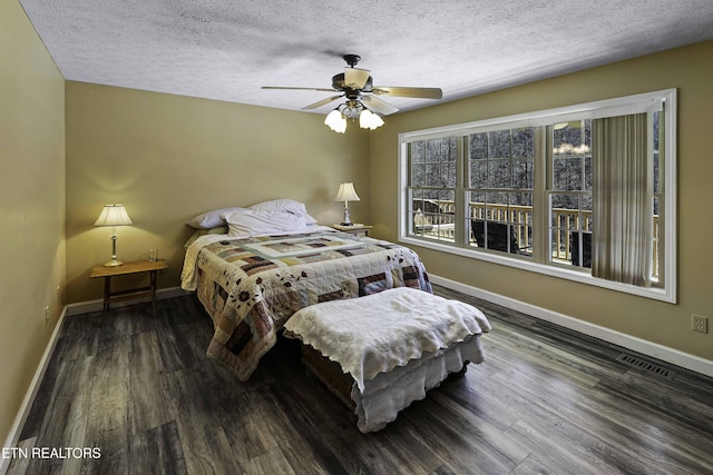 bedroom with wood finished floors, visible vents, and baseboards