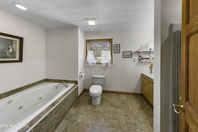 bathroom with toilet, a textured ceiling, vanity, a jetted tub, and baseboards