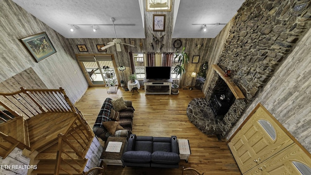 living room featuring a textured ceiling, a fireplace, wood finished floors, and rail lighting