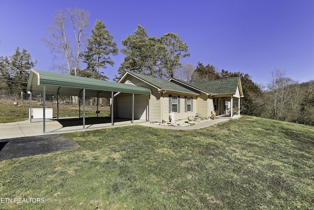 view of front facade featuring a garage, a carport, and a front lawn