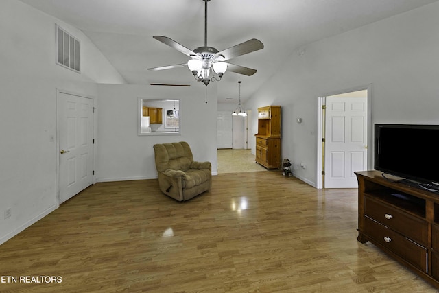 living area with light wood-type flooring, high vaulted ceiling, ceiling fan, and visible vents