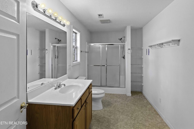 bathroom featuring visible vents, toilet, a shower with shower door, vanity, and baseboards