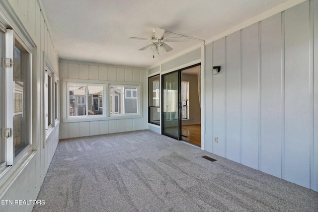 unfurnished sunroom with ceiling fan and visible vents