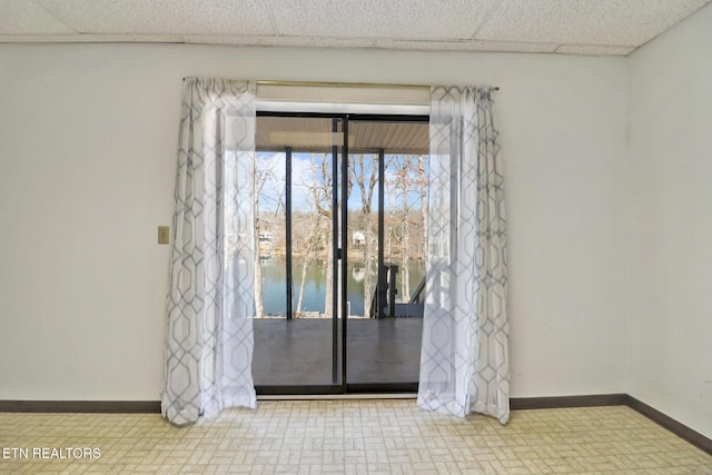 empty room with a drop ceiling and baseboards