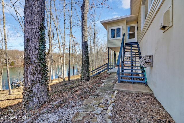 view of yard featuring a water view and stairs