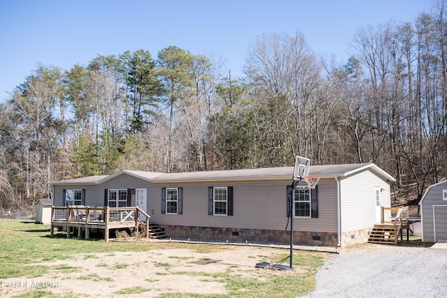 manufactured / mobile home with a front yard, crawl space, and a wooden deck