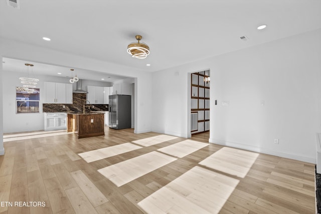 unfurnished living room featuring baseboards, recessed lighting, visible vents, and light wood-style floors