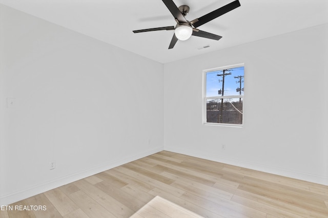 empty room with a ceiling fan, visible vents, baseboards, and wood finished floors