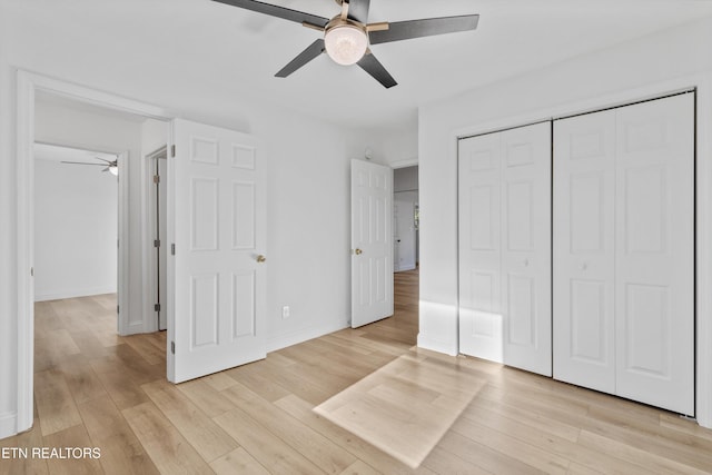 unfurnished bedroom with ceiling fan, a closet, light wood-style flooring, and baseboards