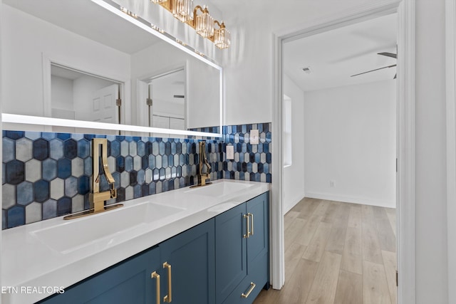 interior space with wood finished floors, tasteful backsplash, a sink, and a ceiling fan