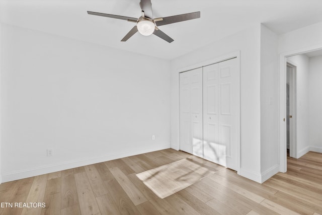 unfurnished bedroom with light wood-type flooring, ceiling fan, baseboards, and a closet